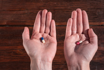 blue and red pill in the palm of your hand, pills in your hands