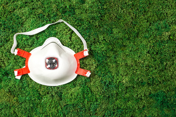 respirator lies on green grass top view, saving the planet, recycling garbage, pollution