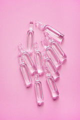 Ampoules for injections with medicine for coronavirus on a pink background. Vaccine for COVID-19. 
