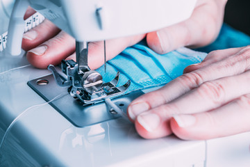 Woman sewing masks in the sewing machine for the COVID-19 pandemic.