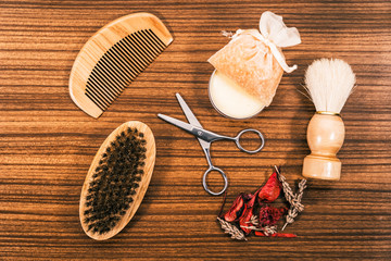 Beauty set with different fragrances on a wooden table. Comb, hair scissors and bath gels among other cosmetic tools.