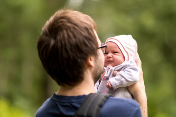 Newborn baby in the arms of his father for a walk