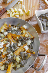 Vegetarian poutine fries with mushroom veggie gravy and topped with cheese chunks. Baked in the oven. 