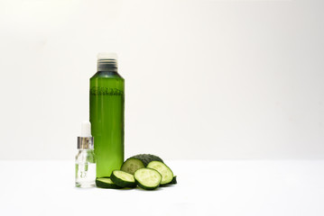 Cosmetic bottles and fresh cucumber on the white background. Natural beauty.