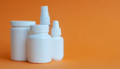 Close-up of three portable plastic bottles with tablets and vitamins and one transparent plastic...