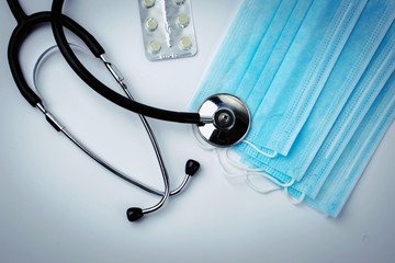 stethoscope, pills in a blister and medical protective masks on white background