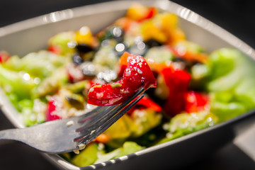 Vegetable Salad. Salad of tomato, cucumber, lettuce, sprinkled with sesame seeds. Salad in a white plate.