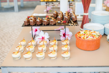 The catering wedding buffet for events. Wedding reception dessert table with delicious decorated white cupcakes with berries closeup.