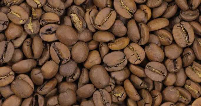 Beautiful rotating black coffee beans. Fresh, invigorated, roasted, fragrant, black. 2 shots.