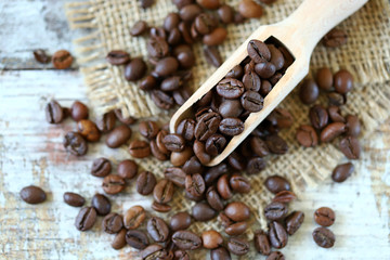 Selective focus. Macro. Grains of coffee in a wooden spatula.