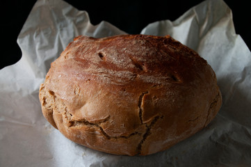 Home made sourdough bread on baking paper. Organic food. Whole grain rye flour.
