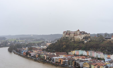 Burg zu Burghausen, castle complex on hill along river during rainy days in Burghausen, Germany