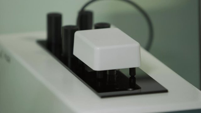 operator putting a sample of water or solution in the chemical measuring instrument close up medical industry