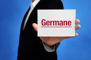 Germane. Lawyer in a suit holds card at the camera. The term Germane is in the sign. Concept for law, justice, judgement