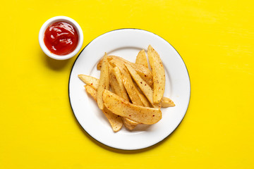 French fries with ketchup sauce on yellow background