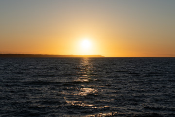 Gorgeous golden sunset over Oresund with Denmark at the horizon. Captured from pier in Helsingborg, Sweden.