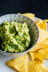 Guacamole fait maison avec des tortillas chips de maïs - Préparation traditionnel mexicaine épicée