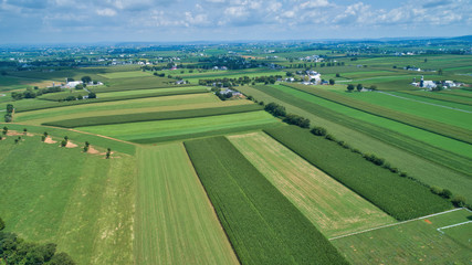 Aerial view of farm lands in summer with blue skies and white fluffy clouds