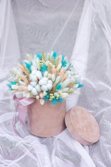 cozy flowers in a 
beige hat box.Floral bouquet of flowers of cotton flowers, gypsophila, wheat and lagurus for a gift for mothers day.