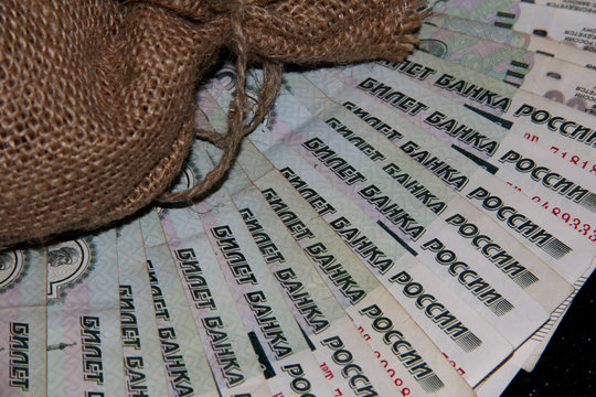 A bag of savings. Banknotes with a face value of 1000 Russian rubles on a black background. Banknote Of The Russian Federation.