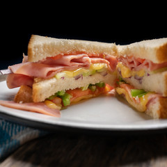 Ham sandwich with cheese on wooden background