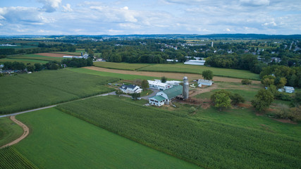 Fototapeta na wymiar Aerial view of Amish countryside with barns and silos on a sunny summer day