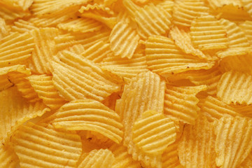 Golden potato chips background. Selective focus, copy space for text