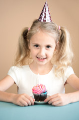  Portrait Caucasian 7 y.o Girl wearing birthday hat  with birthday cake. Happy Birthday Concept.