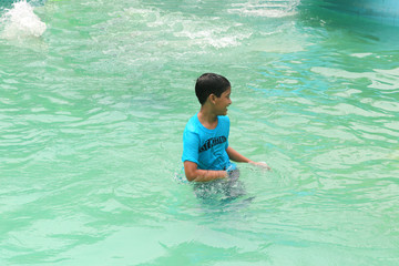 A school boy is enjoing play at water world independently, beautiful wallpaper