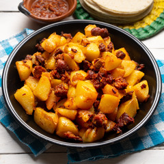 Mexican potatoes with chorizo on white background