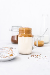 Trendy dalgona coffee in glass on white background.Korean drink latte espresso with foam of instant coffee. New popular food and drink trend. Selective focus