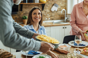 Happy woman enjoying at dining table with her family.
