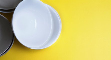 Top view empty plates on yellow background with copy space