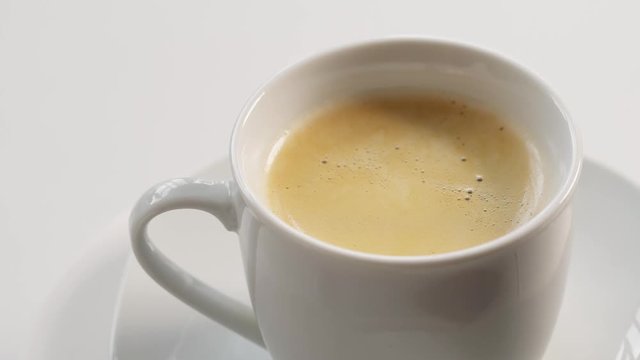 White coffee cup rotation on light background, closeup