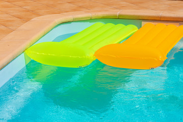 red inflatable mattress in pool