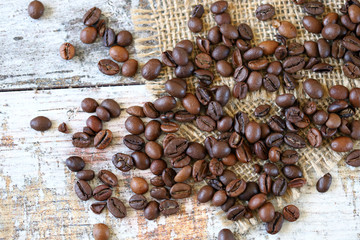 Selective focus. Macro. Coffee beans are scattered on a wooden surface.