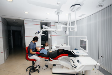 A little girl supports her mother during treatment at the dentist