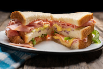 Ham sandwich with cheese on wooden background