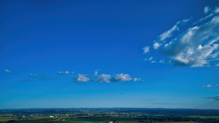 Blue sky and multiple clouds background showing a horizon