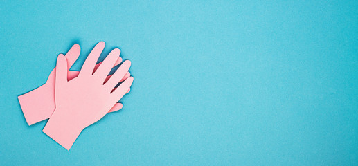 applauding paper hands on a blue background, top view