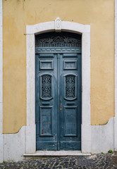 Old vintage rustic blue door. XIX century entrance to an old house. Vertical photo.