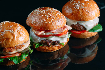 Juicy beef Burgers on a black background.
