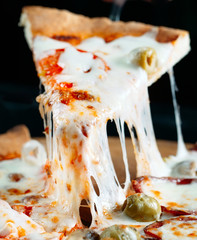 Pizza with very much cheese melting.