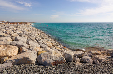 Sea coast with stones, Abu Dhabi ocean beach landscape, Sir Bani Yas island, United Arab Emirates