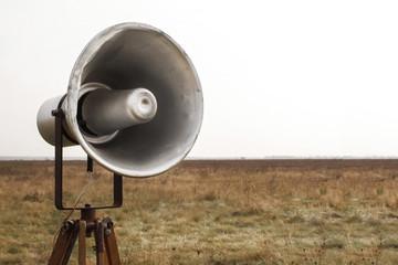 Vintage bullhorn or megaphone with loud speaker. Bullhorn warns of danger. Speaks loudly about the current situation, protest or demonstration. Transmits information to media. Located on a nature.