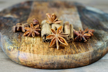Anise star on the wooden kitchen board closeup, macro. Condiments anise and cinnamon on the wooden background closeup.