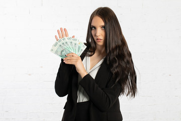 Businesswoman holds Polish banknotes in a fan-shaped hands.