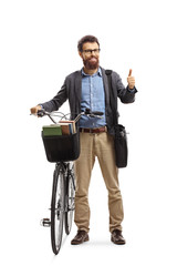 Smiling bearded man standing next to his bicycle and showing thumbs up