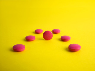 Obraz na płótnie Canvas Drug. Round red tablets on a yellow background. Medicine, pharmaceuticals