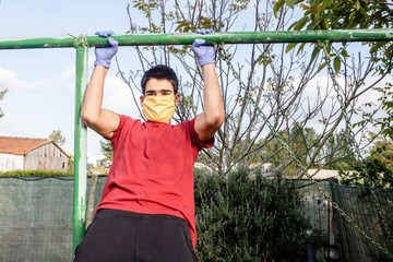 Fototapeta premium Teenager does exercise with mask and gloves during a pandemic. COVID-19. Health care.